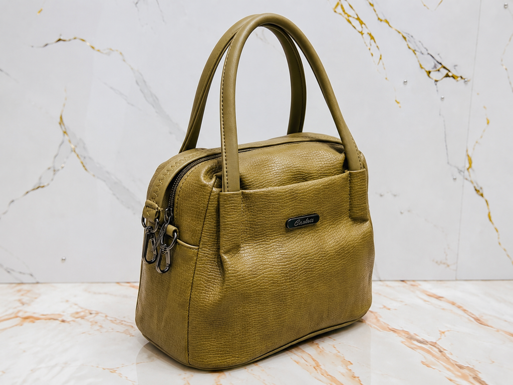 Green handbag on a marble surface with a white marble background