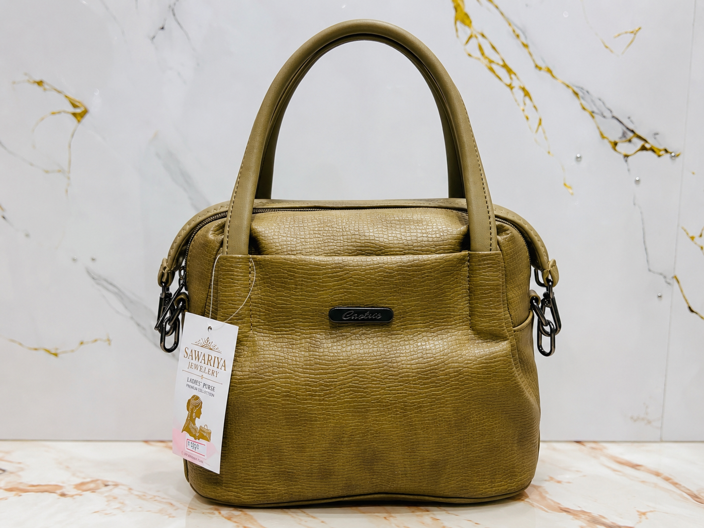 Green handbag with a tag on a marble surface