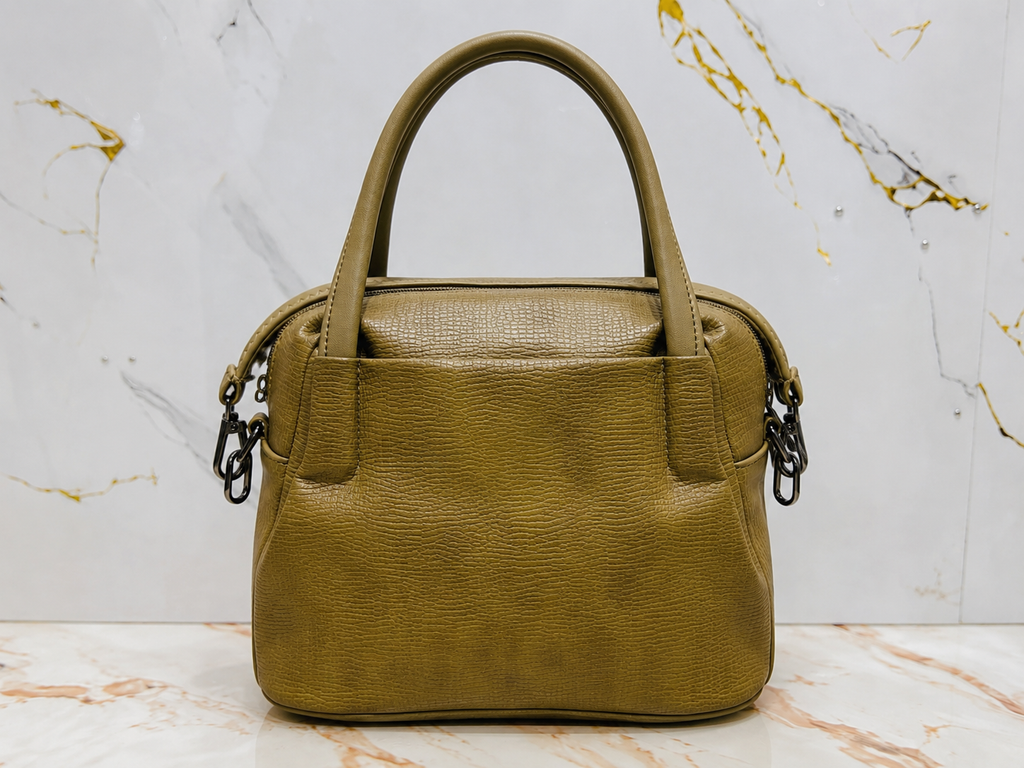Green handbag on a marble surface with a white background
