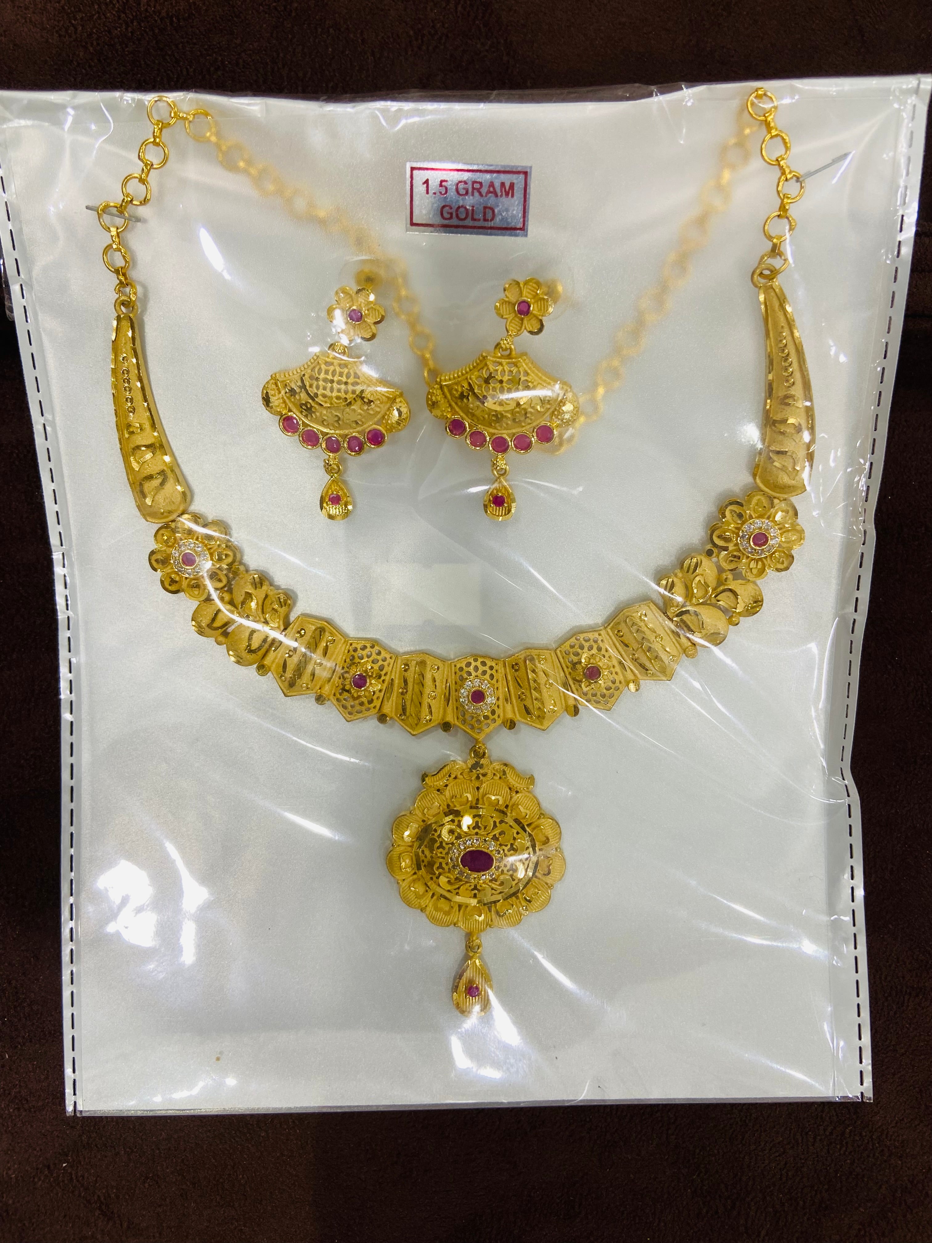 Gold necklace and earrings set on a white card with gold weight label.