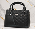 Black quilted handbag on a marble background