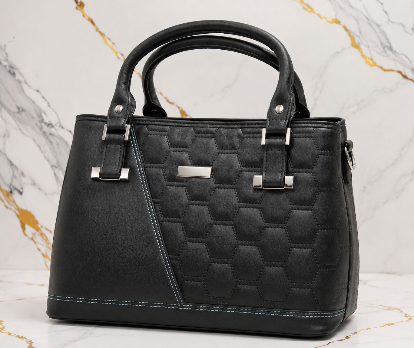 Black quilted handbag on a marble background