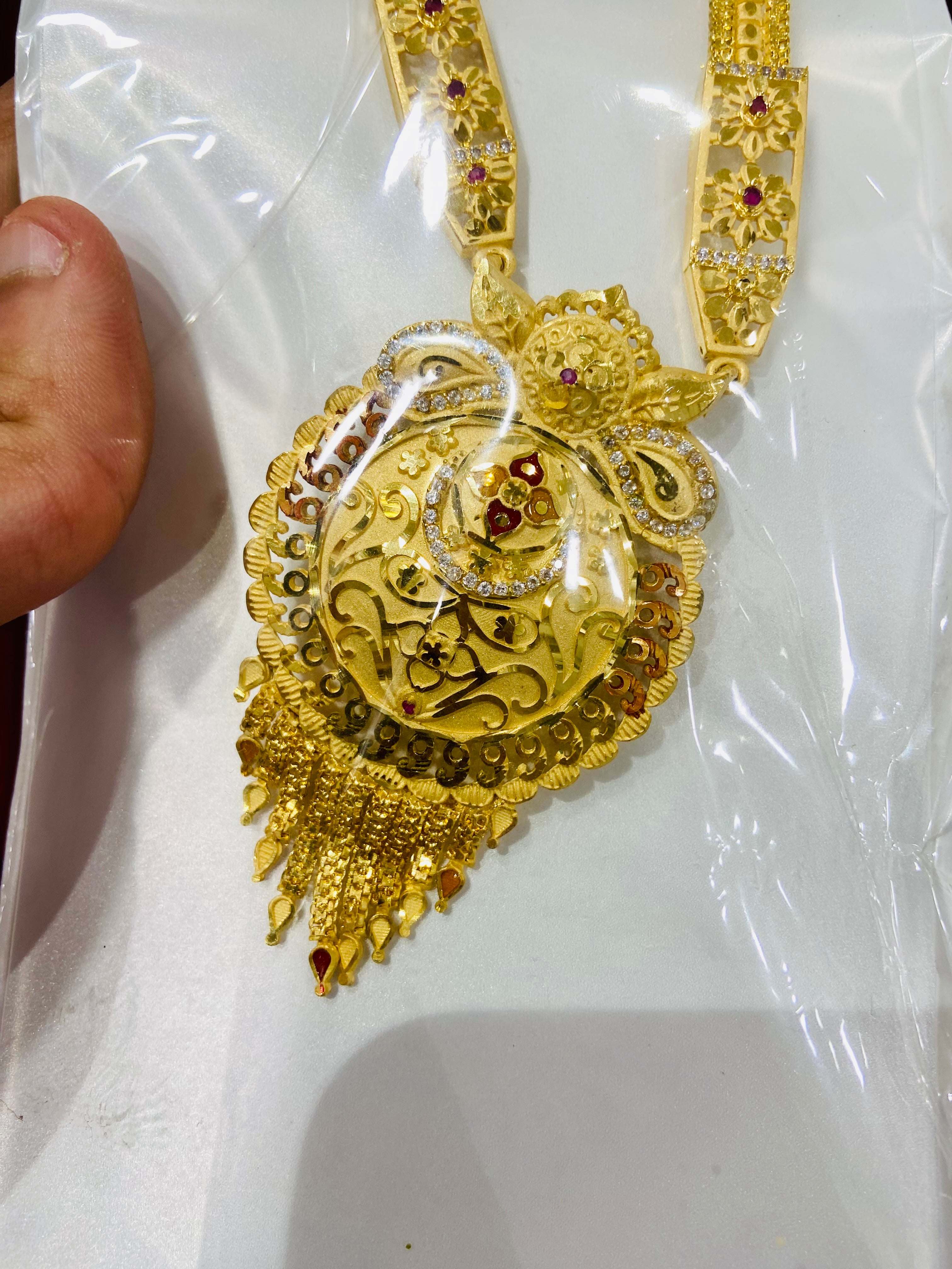 Gold necklace with intricate design on a white background