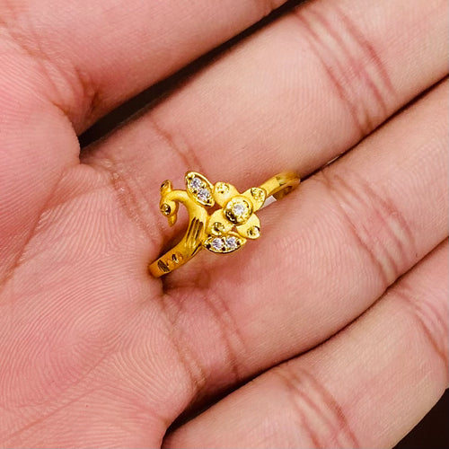 Gold ring with a peacock design on a person's hand