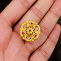 Gold ring with red gemstones held in a hand