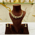 Gold necklace and earrings on a brown mannequin bust with a marble background