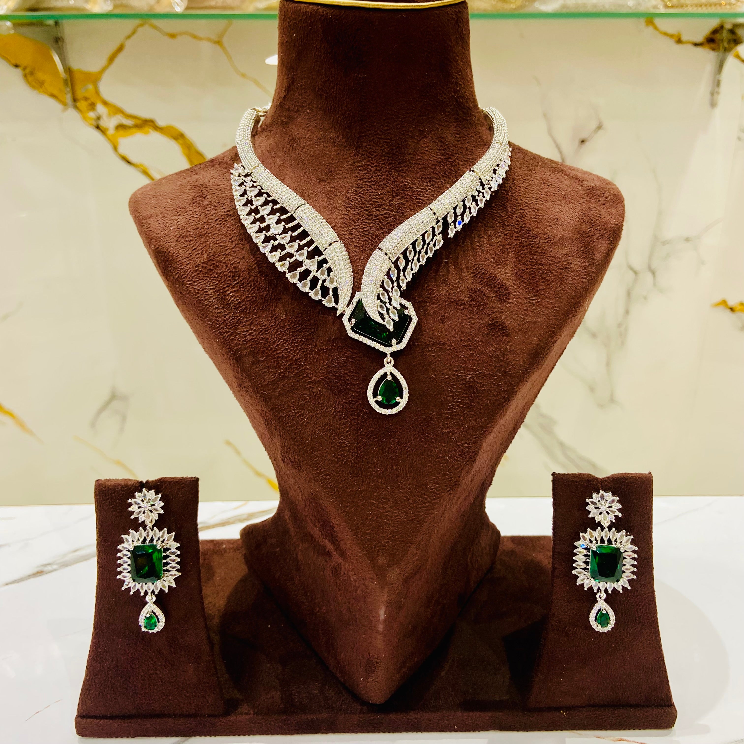 Jewelry set with necklace and earrings on a brown mannequin bust.
