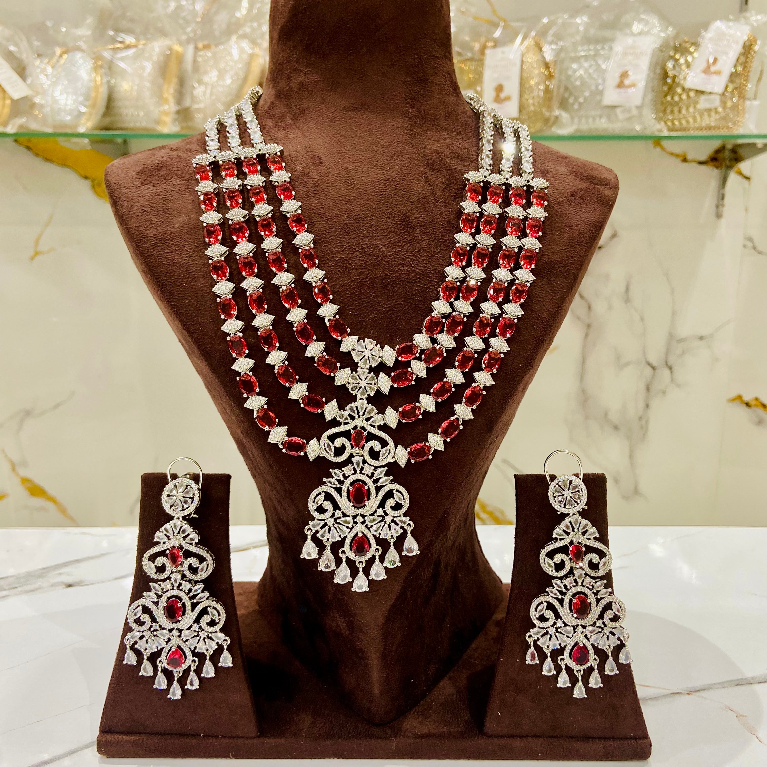 Jewelry set with necklace and earrings on a brown mannequin bust.