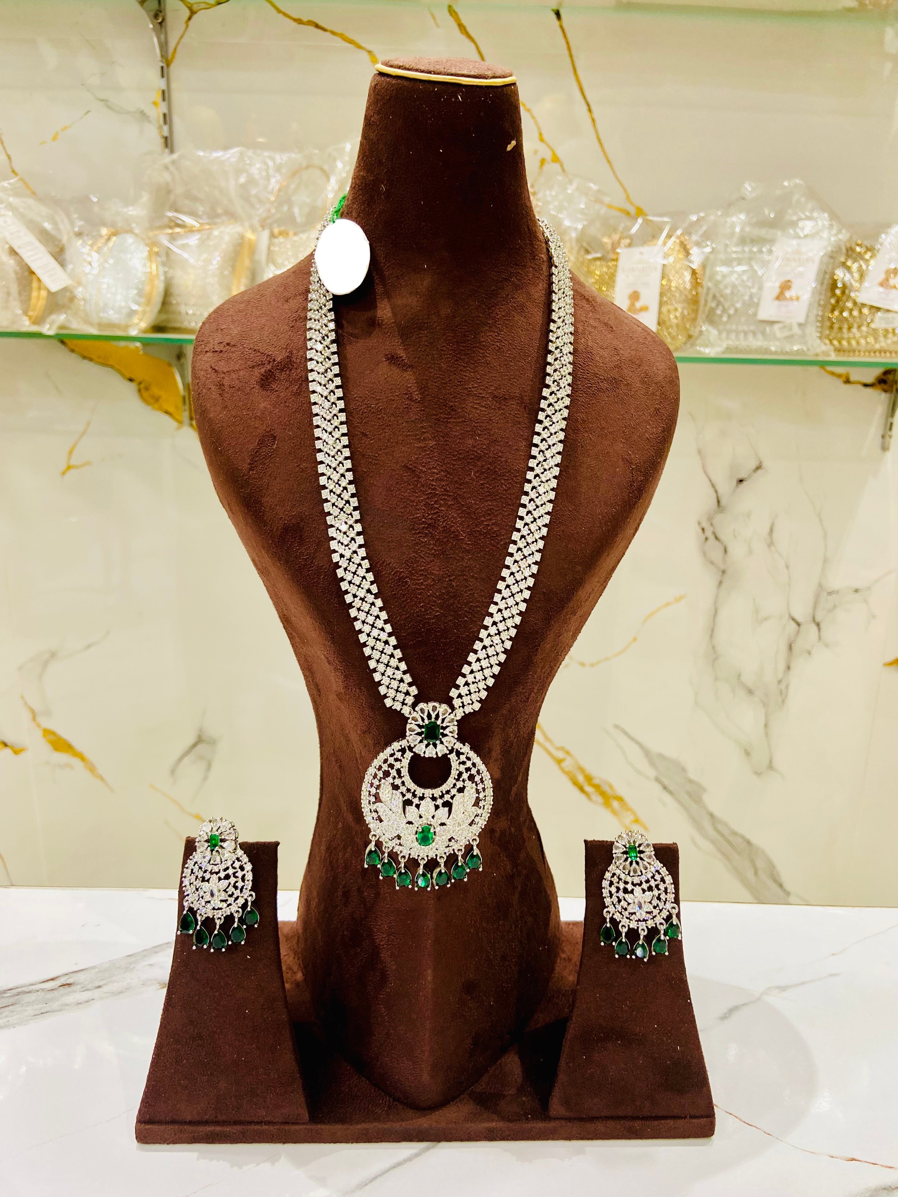 Jewelry set with necklace and earrings on a brown mannequin against a marble background