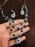 Silver necklace with blue stones held by a hand on a brown background