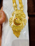 Gold necklace with intricate design held by a hand on a white background