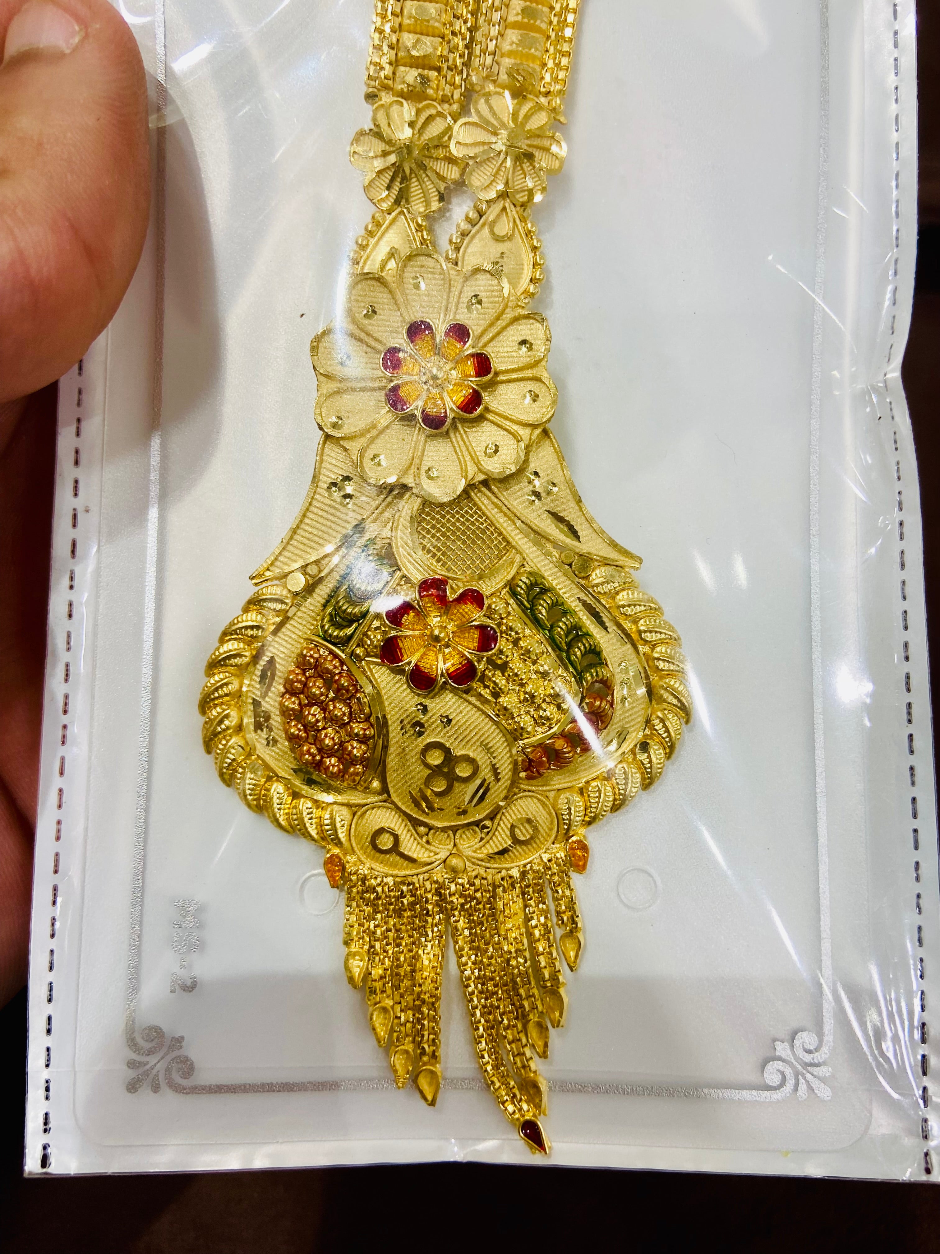 Decorative gold long haar set with floral designs on a white card