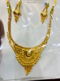 Gold necklace with matching earrings on a white background