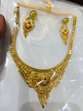 Gold necklace and earrings set on a white card