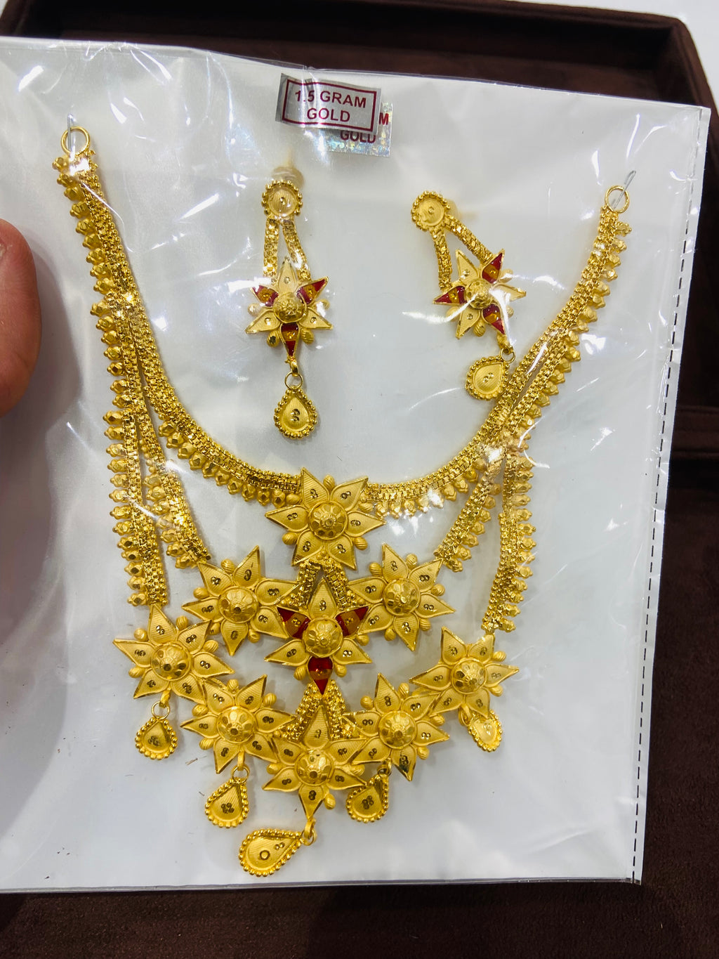 Gold necklace and earrings set on a white card with gold weight label.