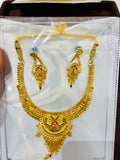 Gold necklace and earrings set on a white card