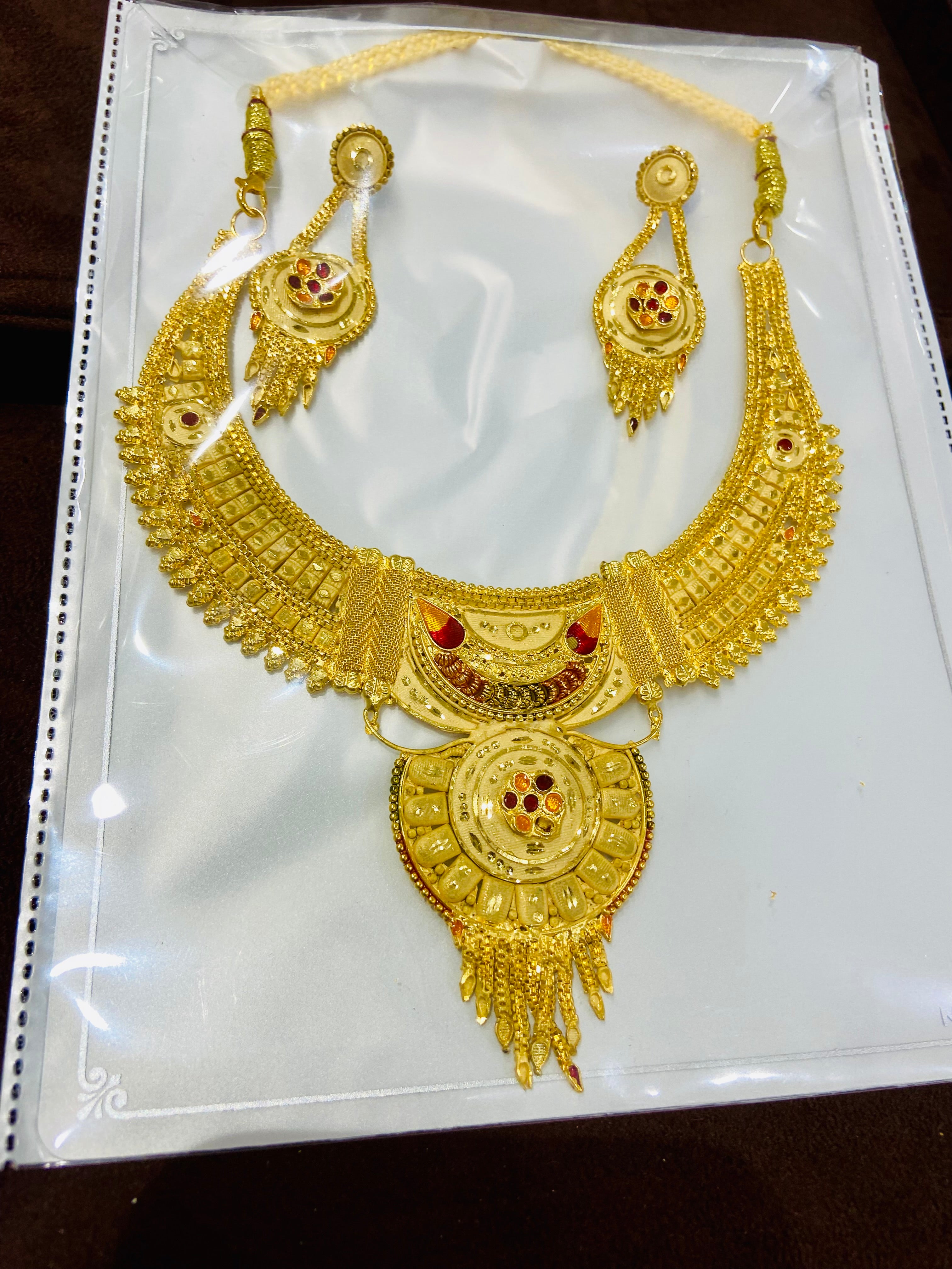 Gold necklace and earrings set on a white background