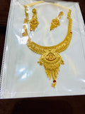 Gold necklace and earrings set on a white card