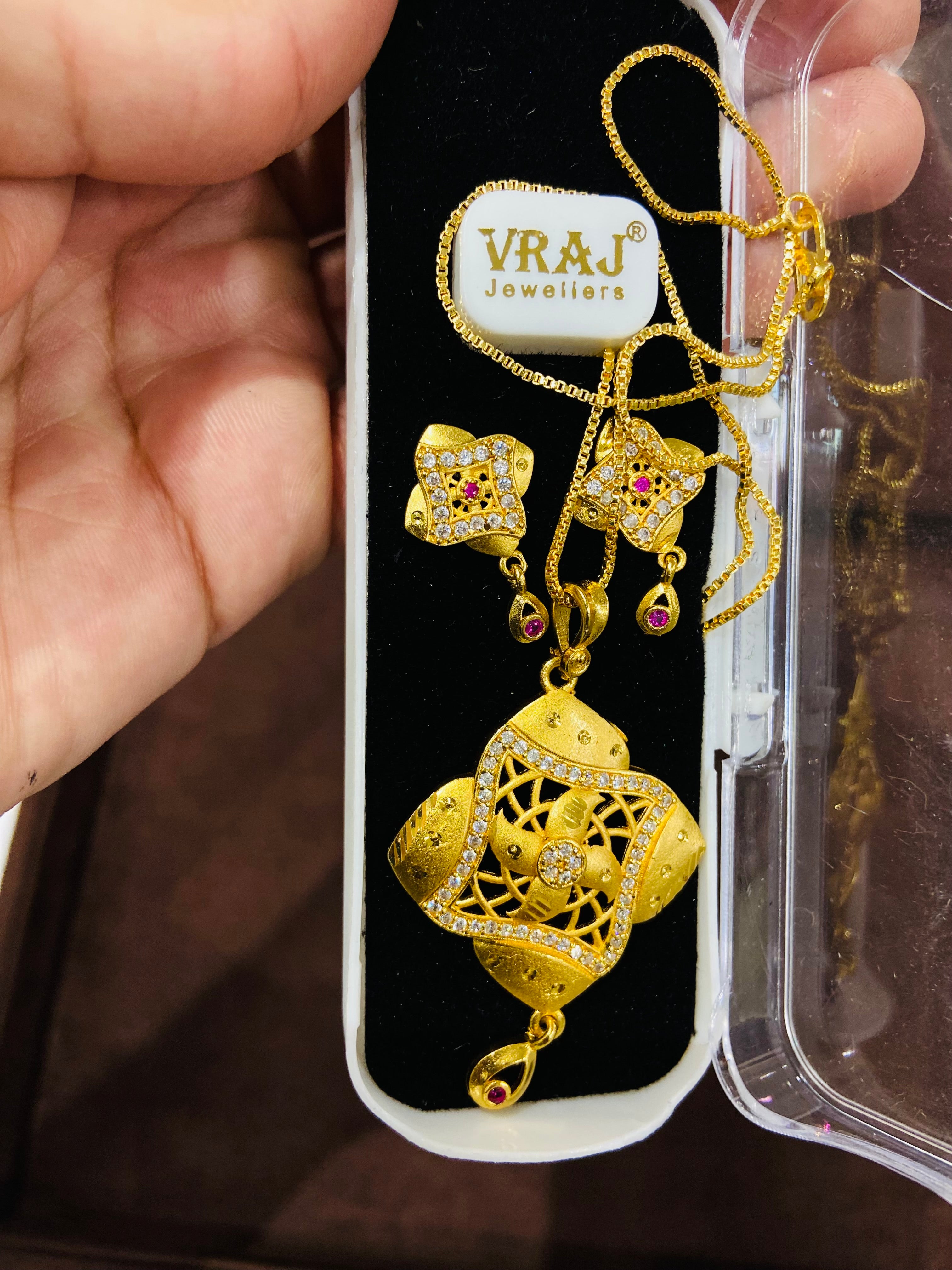 Gold jewelry set with necklace and earrings on a Jewellers branded card.