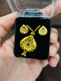 Gold jewelry set with heart design held in a hand