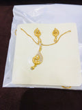 Gold necklace and earrings on a white card with a clear plastic cover