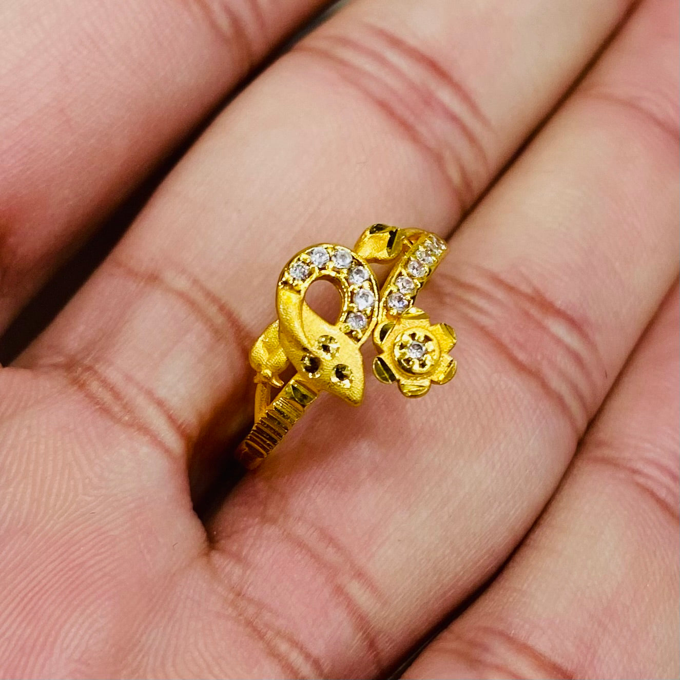 Gold ring with floral design on a hand