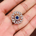 Silver ring with blue gemstone held in a hand