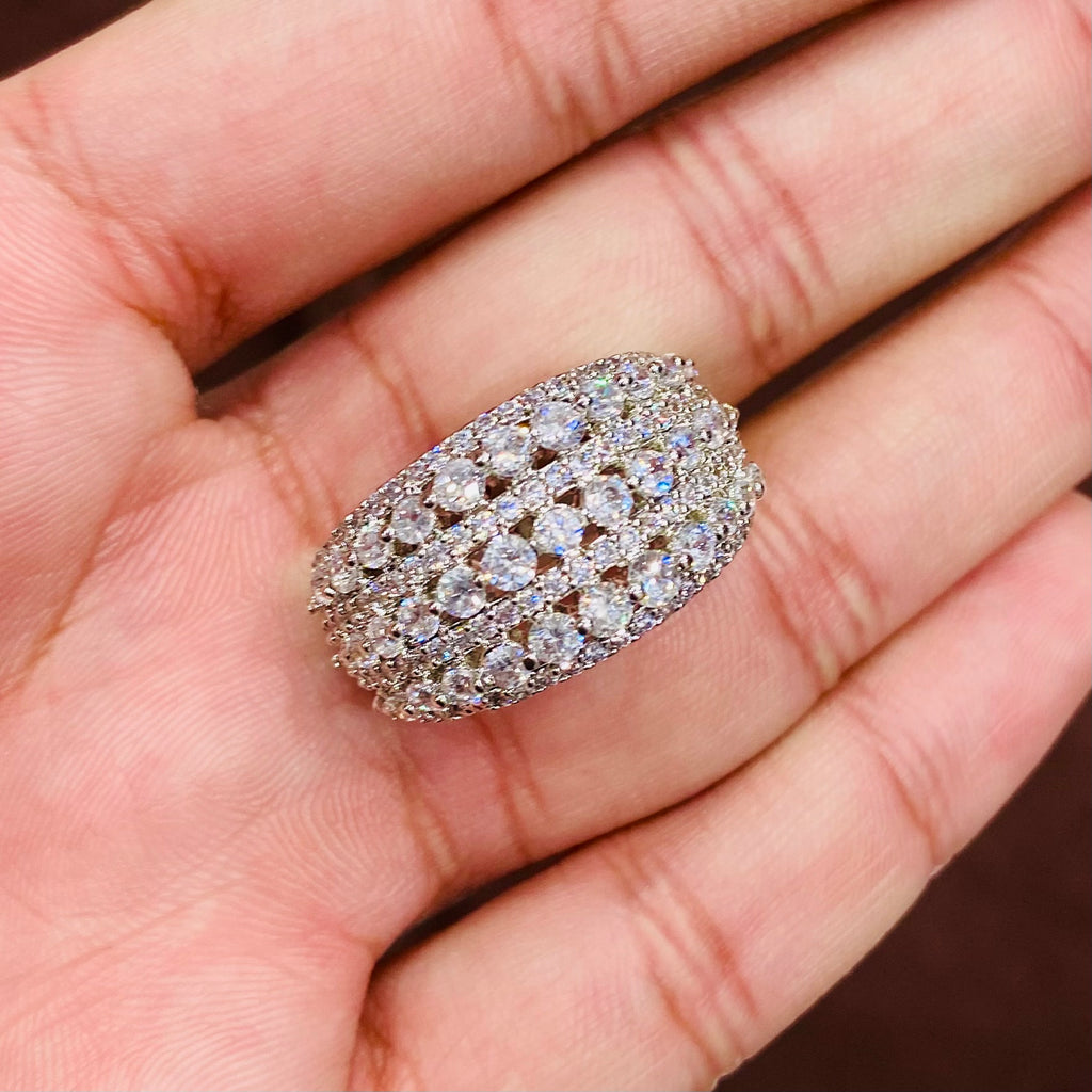 Silver ring with multiple diamonds held in a hand