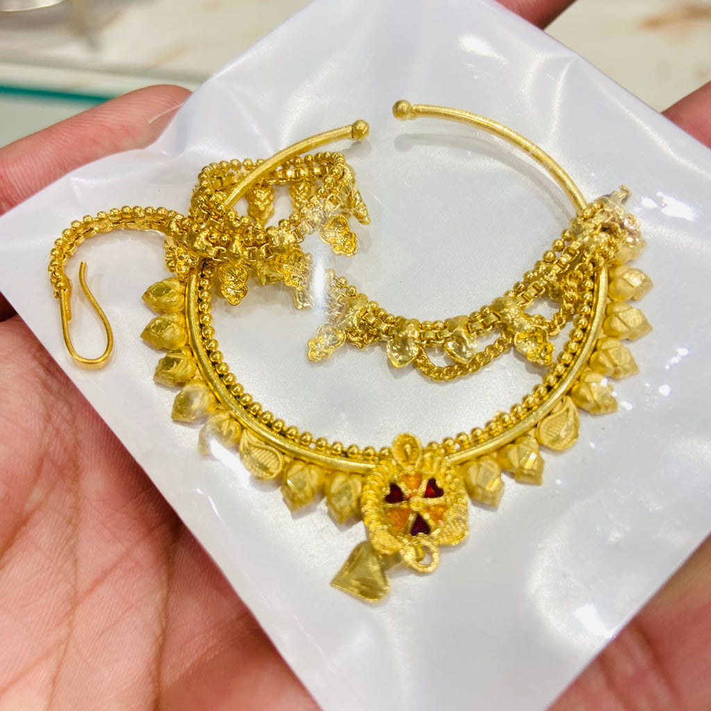 Gold nathiya on a white dish held by a hand