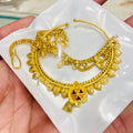 Gold nathiya on a white dish held by a hand