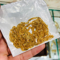 Gold chain held on a white paper with a blurred background
