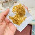 Gold chain on a white paper held by a hand with a blurred background