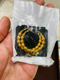 Gold earrings ties in a clear plastic bag held by a hand