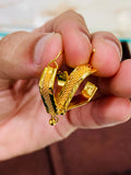 Gold hoop earrings held between fingers against a neutral background