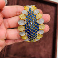 Close-up of a hand holding a decorative bracelet with blue, yellow, and silver stones.