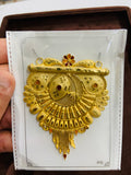 Gold pendant on a white card held by a hand