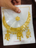 Gold necklace and earrings set on a white card with text
