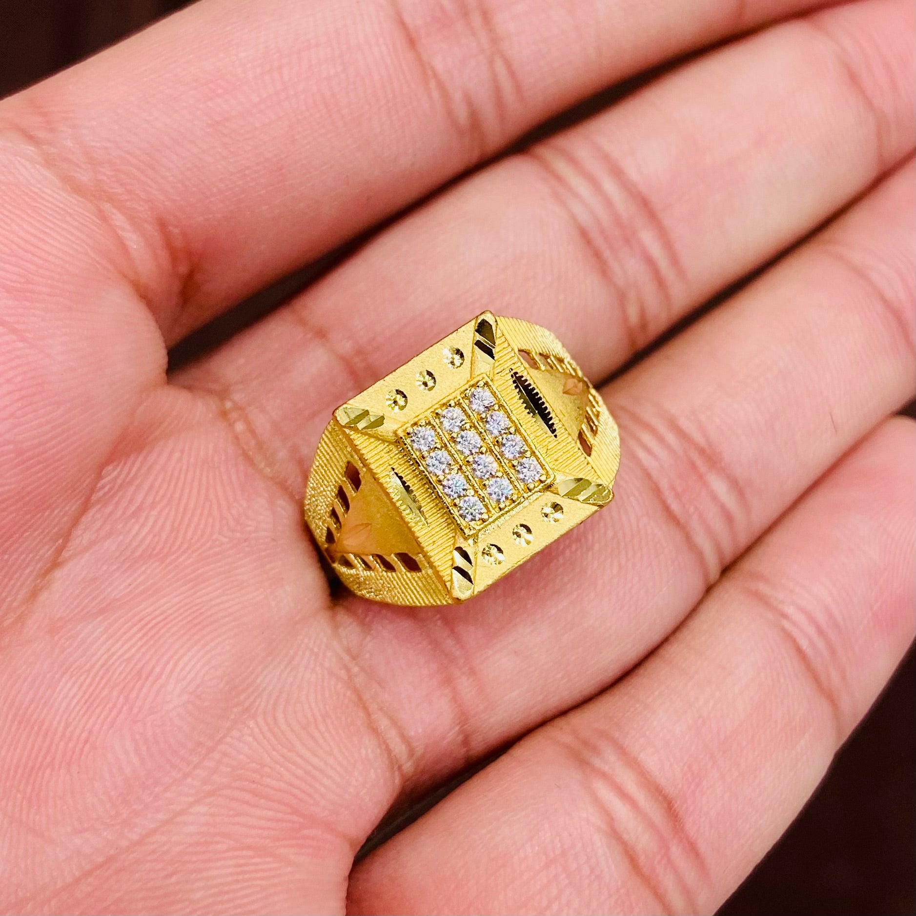 Gold ring with embedded diamonds on a hand
