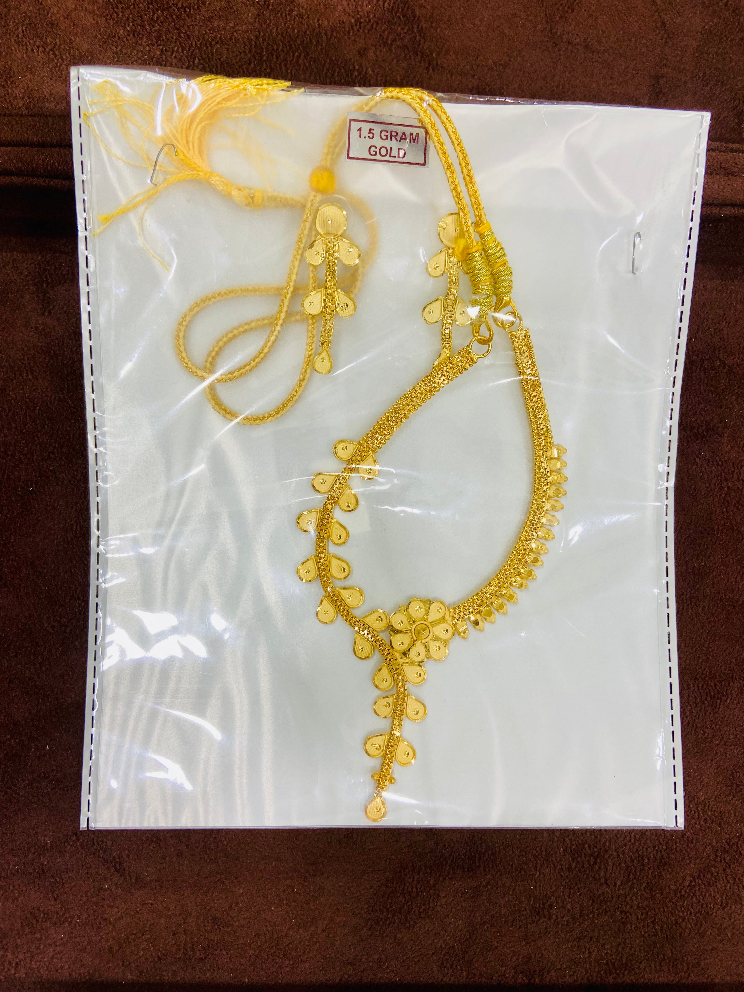 Gold necklace on a white card with gold weight tag