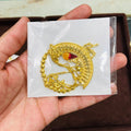 Gold dragon nath on a white card held by a hand with a blurred background