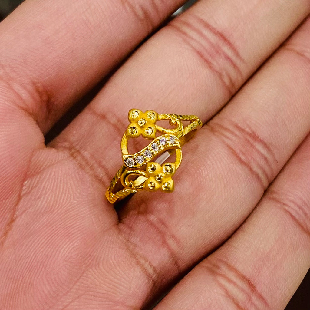 Gold ring with floral design on a hand